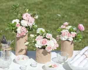 A table with three vases of flowers on it