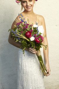 A woman holding a bouquet of flowers in her hands.