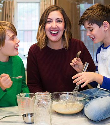 A woman and two boys are sitting at the table